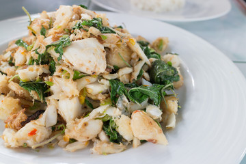 stir fry spicy crab  with basil and chili on white dish, closeup shot