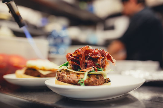 Chef preparing prosciutto burguer in kitchen restaurant