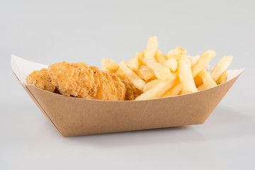 breaded chicken strips with french fries and dipping sauce in carton diner basket