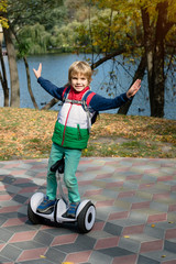 Happy young boy balancing on electric hoverboard