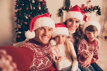 Portrait of four cheerful beautiful bonding hug embrace relatives, at home, married couple, parents, mom and dad, excited siblings, in knitted cute traditional x mas costumes, x mas noel