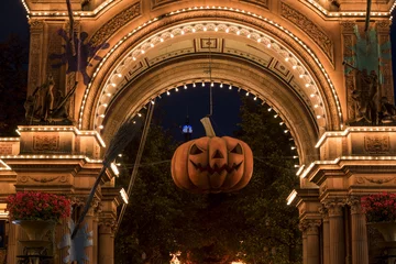 Foto auf Leinwand Halloween pumpkin in front of the illuminated main entrance to Tivoli Gardens, Copenhagen, Denmark © Amaiquez