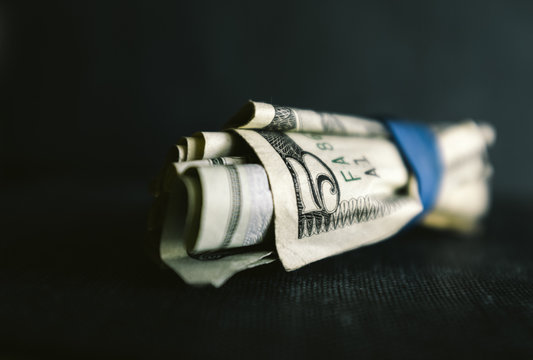 Roll of five US dollar bills