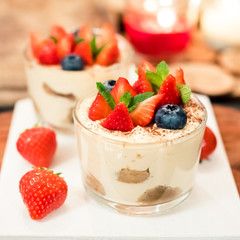 Summer dessert tiramisu, classic cheesecake with berriesand mint leaves.