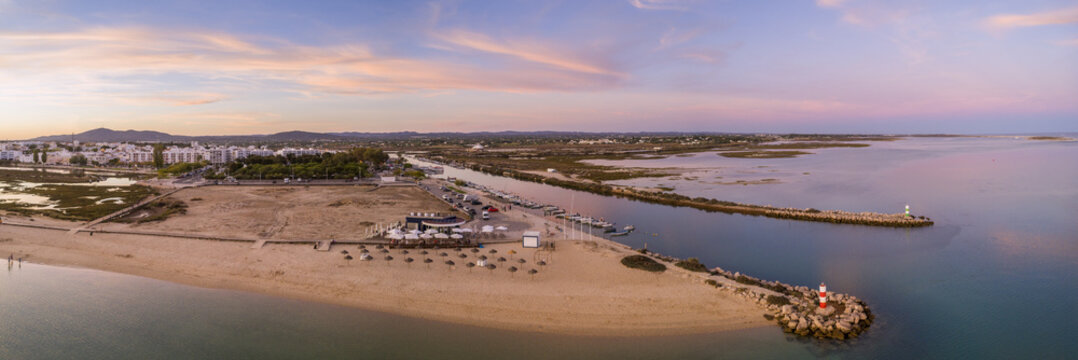 Aerial dusk panoramic view at Fuseta fishing town, in Ria Formosa wetlands nature conservation park, Algarve. Portugal.