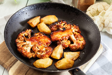 Vegetarian roasted cauliflower steak with herbsand fried potatoes
