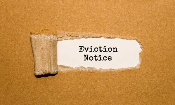 The text Eviction Notice appearing behind torn brown paper