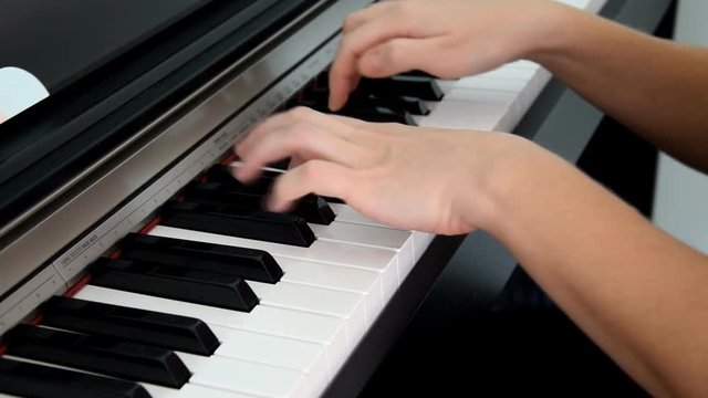 Girl playing the piano. Hands playing the piano.