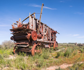 Fototapeta premium Antique threshing machine sits in a field on a farm in South Africa