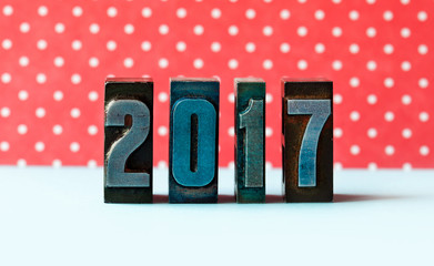 2017 new year concept. Digits written colored vintage letterpress. Red polka dot background.