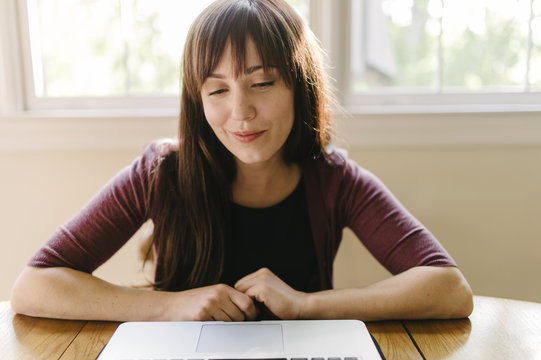 Young woman using video chat on laptop indoors