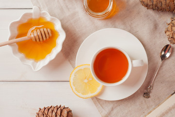White Cup of Tea with Lemon, Honey on Wooden Table Background. Top View. Healthy Concept