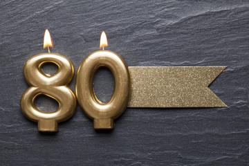 Gold number 80 celebration candle with glitter label