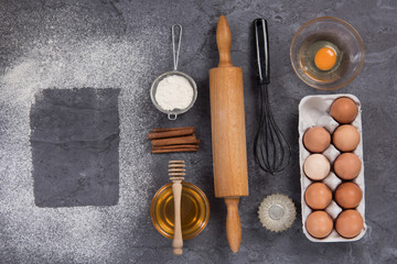 Fototapeta na wymiar Baking utensils and ingredients on stone slate table