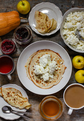 pancakes with cottage cheese and other sweet additives on the wood surface