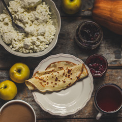 pancakes with cottage cheese and other sweet additives on the wood surface