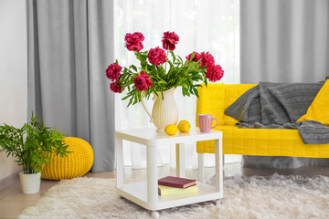 Interior of beautiful light modern room with peony flowers on table