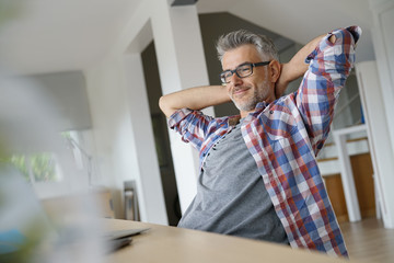 Fototapeta premium Home-office worker stretching arms in front of laptop