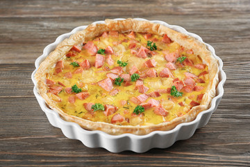Delicious casserole with sausages in baking dish on table