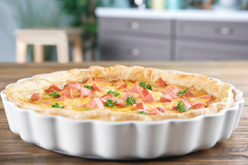 Delicious casserole with sausages in baking dish on table