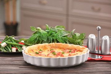 Composition with delicious sausage casserole in baking dish on wooden table