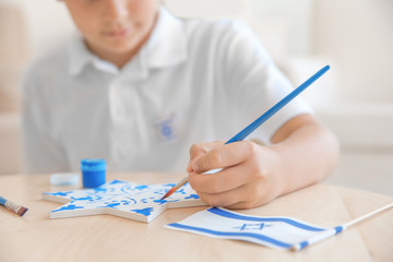 Jewish boy painting up star at home