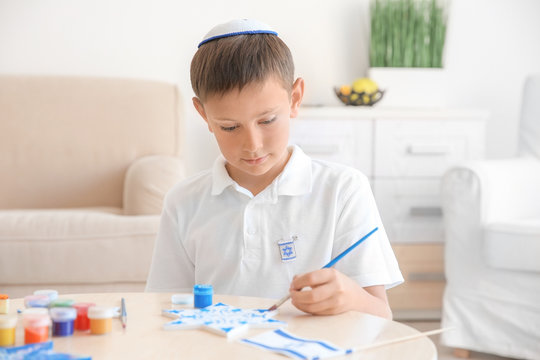 Jewish boy painting up star at home