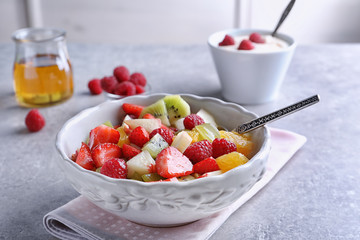 Bowl with delicious fruit salad on table