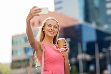 woman with coffee taking selfie by smartphone