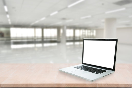 Blank screen computer laptop on wood table on blurred abstract hallway background. can be used for display or montage your product.