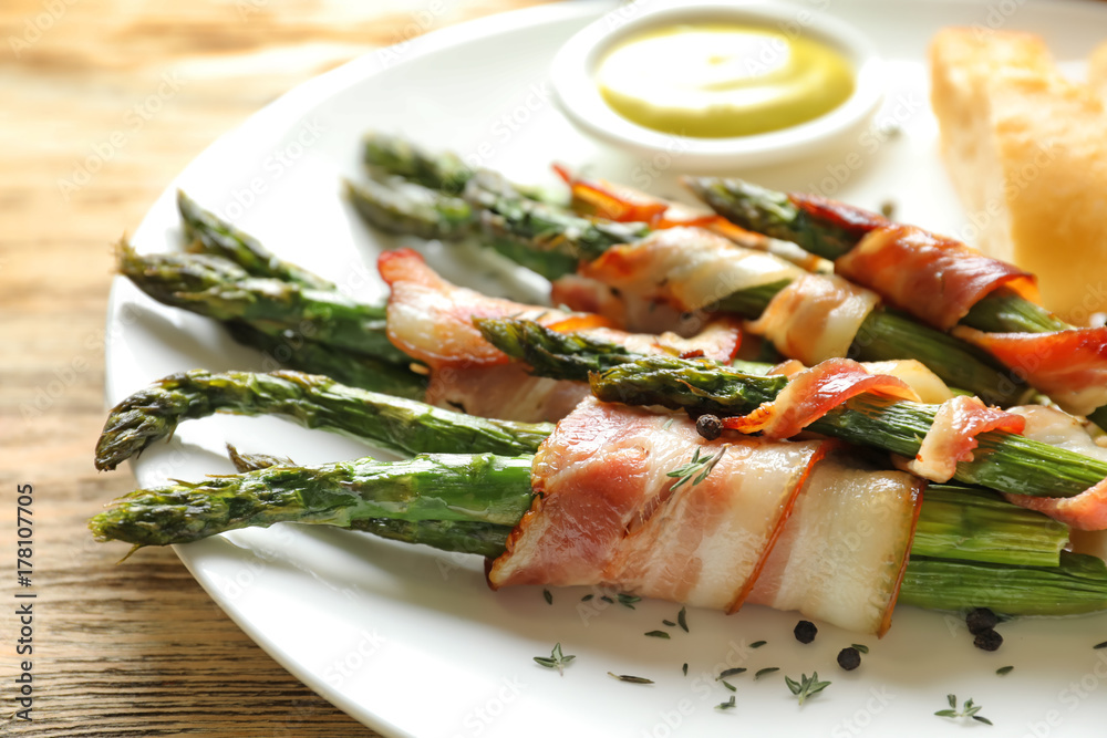 Sticker Plate with bacon wrapped asparagus on table, closeup