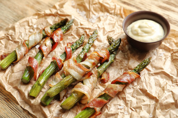 Bacon wrapped asparagus and sauce on table