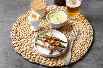 Plate with bacon wrapped asparagus on wicker mat