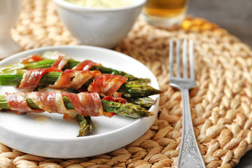 Plate with bacon wrapped asparagus on wicker mat