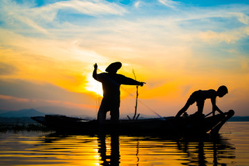 Fishermen who are fishing in the river and a silhouette