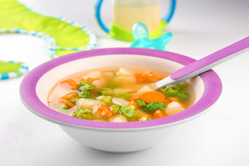 Plate of delicious baby soup on table