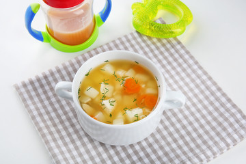 Bowl with delicious baby soup on table