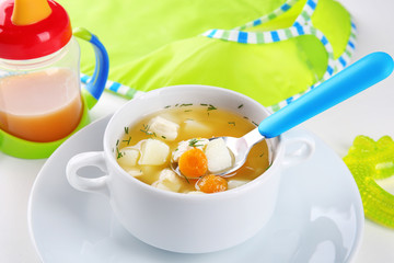 Bowl with delicious baby soup on table
