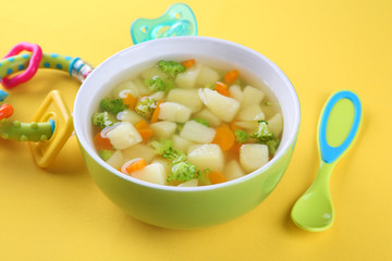 Bowl of delicious baby soup on table
