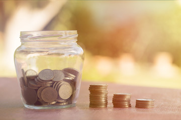 A transparent jar with many coins saved