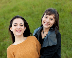 Outdoor portrait of two happy sisters in a park