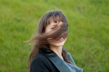 Outdoor portrait of beautiful girl laughing while the wind moves her hair