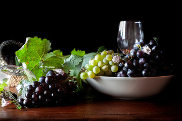 uvas verdes y negras sobre mesa de madera
