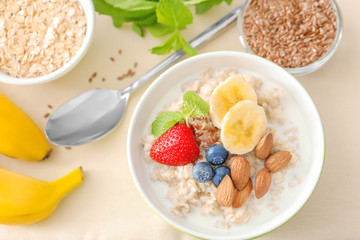 Tasty oatmeal with fruits in bowl on table