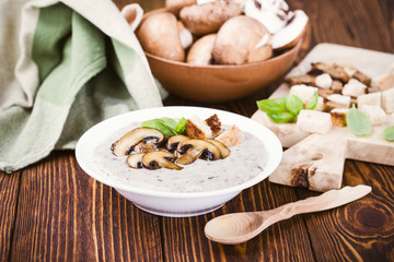 Hot homemade mushroom soup and bowl with fresh raw mushrooms