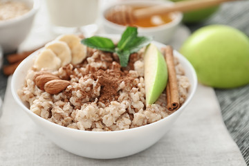 Tasty oatmeal in bowl for breakfast, close up