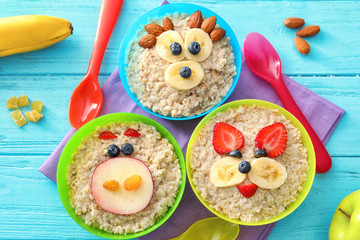 Creative oatmeal in bowls for children on table