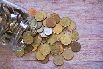 A transparent jar with many coins saved