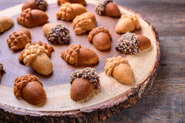 Healthy homemade Maple Acorn Cakelets, acorn shape cookies on wood slice serving board, server, tray. Closeup.
