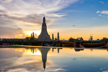 Fototapeta na wymiar Sunset Wat Arun (Temple of Dawn) and Reflections of Wat Arun Pagoda on glass table is landmark of Attractions's Popular tourists, in bangkok Thailand